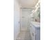 Well-lit bathroom featuring tiled shower, glass door, marble top vanity, and black and white tiled flooring at 1110 W Heatherbrae Dr, Phoenix, AZ 85013