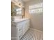 Charming bathroom with white vanity, marble countertop, and elegant black-and-white tiled floor at 1110 W Heatherbrae Dr, Phoenix, AZ 85013