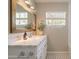 Bright bathroom featuring a marble vanity top, framed mirror, and stylish black and white tile flooring at 1110 W Heatherbrae Dr, Phoenix, AZ 85013