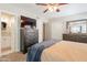 Comfortable bedroom features a dresser, ceiling fan, a bed with throw blanket and an attached bathroom at 1110 W Heatherbrae Dr, Phoenix, AZ 85013