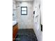 Modern bathroom featuring black hexagon tiles, light gray wall tiles, and a frameless glass shower enclosure at 1111 E Coronado Rd, Phoenix, AZ 85006