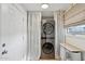 Convenient laundry area with stacked washer and dryer, window, and built-in storage space at 1111 E Coronado Rd, Phoenix, AZ 85006