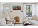 Inviting living room highlighting the white fireplace with built-in wood storage and a large window with natural light at 1111 E Coronado Rd, Phoenix, AZ 85006