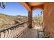 This balcony offers beautiful views with wrought iron railings, stone pillars, and overlooks natural desert landscaping at 11550 E Paradise Ln, Scottsdale, AZ 85255