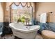 Bright bathroom featuring a clawfoot tub and a view at 11550 E Paradise Ln, Scottsdale, AZ 85255