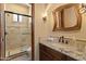 Bathroom with a walk-in shower, decorative mirror, marble countertop, and under-sink cabinet at 11550 E Paradise Ln, Scottsdale, AZ 85255