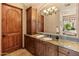 Bathroom featuring wood cabinetry and vanity with an arched mirror at 11550 E Paradise Ln, Scottsdale, AZ 85255