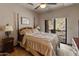 Comfortable bedroom featuring a four-poster bed and sliding doors to an outdoor area at 11550 E Paradise Ln, Scottsdale, AZ 85255
