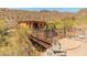 A charming bridge leads to the home's entrance, with wrought iron details and desert landscaping at 11550 E Paradise Ln, Scottsdale, AZ 85255