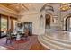 Grand dining area featuring a glass table, ornate chairs, and staircase at 11550 E Paradise Ln, Scottsdale, AZ 85255