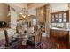 Elegant dining room featuring a glass table, ornate chairs, and a stone fireplace at 11550 E Paradise Ln, Scottsdale, AZ 85255