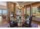 Dining room with fireplace, elegant chandelier, and scenic outdoor views at 11550 E Paradise Ln, Scottsdale, AZ 85255