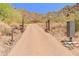Brick paved driveway leading to a luxury home with desert landscaping and mountain views at 11550 E Paradise Ln, Scottsdale, AZ 85255