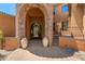 Grand front entrance with stone archway, decorative pots, and elegant iron door at 11550 E Paradise Ln, Scottsdale, AZ 85255