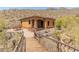 Exterior view of the home featuring an entry bridge, tile roof, and desert landscape at 11550 E Paradise Ln, Scottsdale, AZ 85255