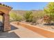 Desert landscaping and a walkway create a natural and inviting entrance to the home with stone accents at 11550 E Paradise Ln, Scottsdale, AZ 85255