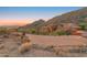 Luxury home featuring a brick driveway and scenic mountain views at dusk at 11550 E Paradise Ln, Scottsdale, AZ 85255
