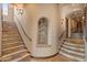 Elegant hallway featuring tiled steps, niches, and decorative lighting fixtures at 11550 E Paradise Ln, Scottsdale, AZ 85255