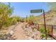 Scenic desert landscaping with cacti and lush greenery leads to the front door of this property at 11550 E Paradise Ln, Scottsdale, AZ 85255