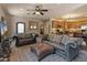 Inviting living room featuring leather sofas, ceiling fan, and open access to the kitchen area at 11550 E Paradise Ln, Scottsdale, AZ 85255