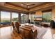 Bright living room with hardwood floors, comfortable leather seating, and panoramic outdoor views at 11550 E Paradise Ln, Scottsdale, AZ 85255