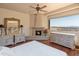 Bright main bedroom with a fireplace, ceiling fan, dual vanities, and a large picture window with mountain views at 11550 E Paradise Ln, Scottsdale, AZ 85255