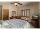 Serene main bedroom with a ceiling fan, dresser, and scenic outdoor views through shuttered windows at 11550 E Paradise Ln, Scottsdale, AZ 85255