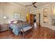 Comfortable main bedroom featuring a fireplace, ceiling fan and hardwood floors at 11550 E Paradise Ln, Scottsdale, AZ 85255