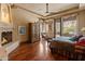 Comfortable main bedroom featuring a fireplace, ceiling fan and hardwood floors at 11550 E Paradise Ln, Scottsdale, AZ 85255