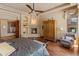Comfortable main bedroom featuring a fireplace, ceiling fan and hardwood floors at 11550 E Paradise Ln, Scottsdale, AZ 85255