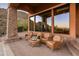 Covered patio with stone accents, comfortable seating, and beautiful desert views for outdoor relaxation and enjoyment at 11550 E Paradise Ln, Scottsdale, AZ 85255