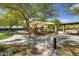 Covered playground with slides, climbing structures, picnic tables, and lush desert landscaping at 11550 E Paradise Ln, Scottsdale, AZ 85255