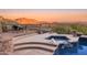 Inviting hot tub and pool featuring stone accents, and stunning mountain views at dusk at 11550 E Paradise Ln, Scottsdale, AZ 85255
