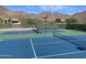 Well-maintained blue and green tennis court with mountain views in a residential community at 11550 E Paradise Ln, Scottsdale, AZ 85255