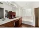 Bright bathroom features wood cabinets, double sinks and a soaking tub at 13137 W Wilshire Dr, Goodyear, AZ 85395