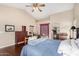 Well-lit main bedroom with ensuite bathroom featuring wood flooring and ceiling fan at 13137 W Wilshire Dr, Goodyear, AZ 85395