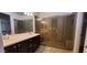 Elegant bathroom with double sinks, dark wood cabinets, and a spacious glass-enclosed shower at 15424 N 22Nd Ln, Phoenix, AZ 85023