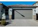 Close-up of a two car garage door with brick paver driveway and desert landscaping at 15424 N 22Nd Ln, Phoenix, AZ 85023