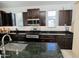 Stylish kitchen with dark wood cabinets, granite countertops, and stainless steel appliances for cooking gourmet meals at 15424 N 22Nd Ln, Phoenix, AZ 85023