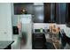 Cozy kitchen with stainless steel refrigerator, dark cabinets and black countertops offers a functional layout at 15424 N 22Nd Ln, Phoenix, AZ 85023