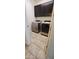 Convenient laundry room with modern washer and dryer, upper cabinets, and tiled flooring at 15424 N 22Nd Ln, Phoenix, AZ 85023