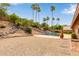 Beautiful backyard featuring a sparkling pool, a slide, desert landscaping, and mature palm trees at 15430 N 19Th Way, Phoenix, AZ 85022