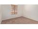 A sunlit bedroom with a window featuring blinds and soft carpet flooring at 15430 N 19Th Way, Phoenix, AZ 85022