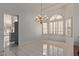 Elegant dining room with tile floors, chandelier, and large arched window with decorative shutters at 15430 N 19Th Way, Phoenix, AZ 85022