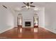 Spacious living room featuring a fireplace, hardwood floors, ceiling fan, and double patio doors at 15430 N 19Th Way, Phoenix, AZ 85022