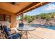 Covered patio featuring comfortable seating area, offering a view of the lush backyard with a sparkling pool and a slide at 15430 N 19Th Way, Phoenix, AZ 85022