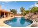 Inviting pool featuring a rock waterfall, slide, desert landscaping and an expansive patio area at 15430 N 19Th Way, Phoenix, AZ 85022