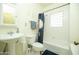 Clean, simple bathroom with pedestal sink, white tiles, and patterned shower curtain at 1650 N 10Th St, Phoenix, AZ 85006