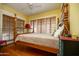 Cozy bedroom with hardwood floors, wood-slat blinds, and wooden four-poster bed at 1650 N 10Th St, Phoenix, AZ 85006