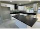 Well-lit kitchen with white cabinets, black countertops, and an island at 1720 W Michigan Ave, Phoenix, AZ 85023